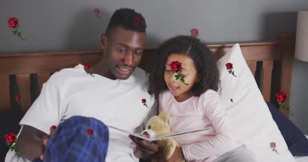 Анімація Троянд Над Щасливим Афроамериканським Батьком Дочкою Читають Книгу Ліжку — стокове відео