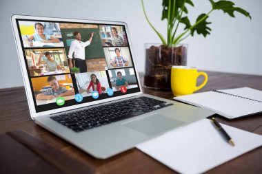 Dizüstü bilgisayar ekranında sınıf sırasında gülümseyen çeşitli ilkokul öğrencileri. iletişim teknolojisi ve çevrimiçi eğitim, dijital kompozit resim.