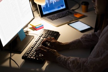 Çift ırklı kadın programcı masada oturuyor, ekranında kodlama olan bir bilgisayar kullanıyor. Kodlama, programlama ve bilgisayar teknolojisi dijital kompozit görüntü.