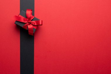 Gri ve pembe arkaplanlı pembe kurdeleli mevcut kompozisyon. Perakende, alışveriş ve Kara Cuma konsepti.