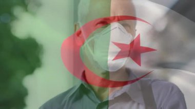 Cezayir bayrağının şehir caddesinde yüz maskesi takan beyaz adamın üzerinde dalgalanması. covid 19 salgın konsepti boyunca dijital olarak üretilen küresel sağlık önlemleri.