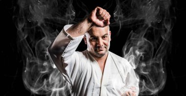 Siyah arka plandaki duman izlerinin üzerinde erkek dövüş sanatçısının kompozisyonu. spor ve yarışma konsepti dijital olarak oluşturulmuş görüntü.