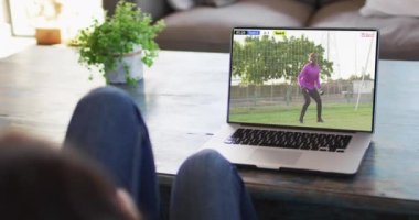 Kanepede oturup dizüstü bilgisayardan futbol maçı izleyen birinin videosu. Futbol ve tezahürat kavramı.