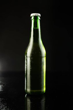 Beyaz kapaklı yeşil cam bira şişesi resmi, siyah arka planda kopyalama alanı var. Alkol, içecek ve bira günü kutlamaları..