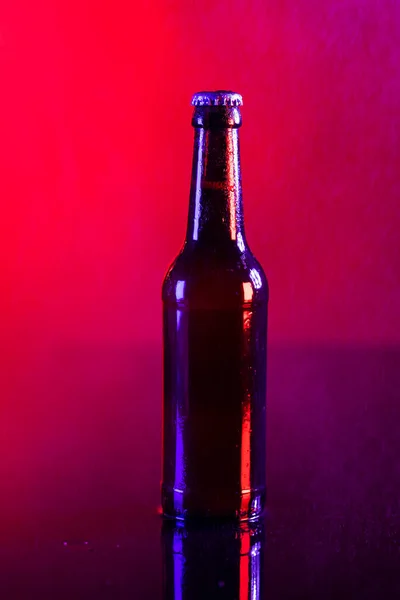 赤の背景にコピースペースとクラウンキャップと茶色のガラスラガービールボトルのイメージ アルコール リフレッシュメント ラガーデーのお祝いのコンセプト — ストック写真