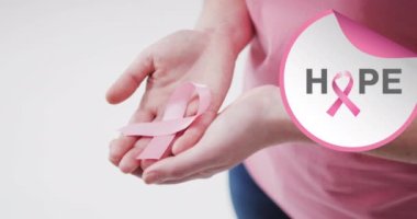 Beyaz arka planda pembe kurdeleli beyaz kadın için umut mesajı. Göğüs kanseri farkındalığı konsepti dijital olarak üretilen video.