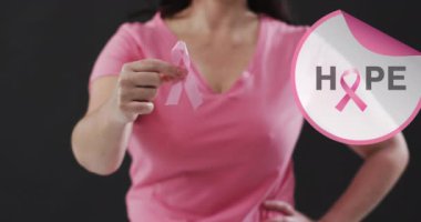 Siyah arka planda pembe kurdeleli beyaz bir kadın için umut mesajı. Göğüs kanseri farkındalığı konsepti dijital olarak üretilen video.