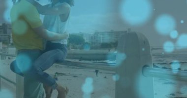 Sahilde kucaklaşan Afrikalı Amerikalı çiftin üzerindeki ışık noktalarının canlandırması. Yaşam tarzı, boş zaman ve tatil konsepti dijital olarak oluşturulmuş video.