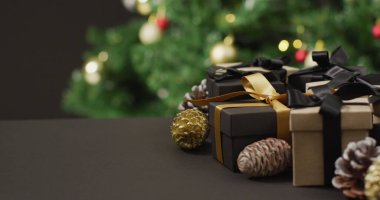 Çam kozalaklı noel hediyeleri ve siyah arka planda fotokopi alanı. Noel, gelenek ve kutlama konsepti.