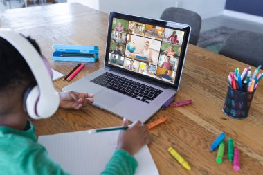 Ekranda farklı ilkokul öğrencileri olan Afro-Amerikan çocuk, video görüşmesi için dizüstü bilgisayar kullanıyor. iletişim teknolojisi ve çevrimiçi eğitim, dijital kompozit resim.