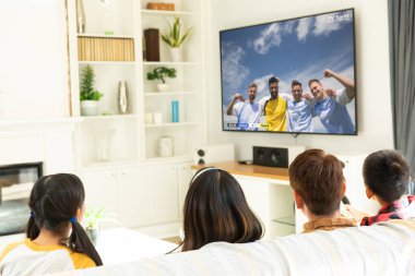 Çeşitli çocuklar televizyonda futbol maçı izliyorlar. Küresel spor ve kutlama konsepti, dijital kompozit görüntü.