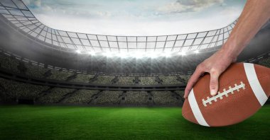 Erkek rugby oyuncusunun spor stadyumunun üzerinde rugby topu tutuşu. spor ve yarışma konsepti dijital olarak oluşturulmuş görüntü.