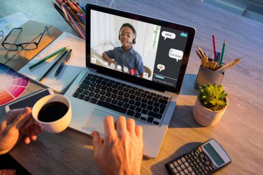 Ekranda Afro-Amerikan ilköğretim öğrencisinin olduğu bilgisayarla video görüşmesi yapan adamın elleri. iletişim teknolojisi ve çevrimiçi eğitim, dijital kompozit resim.