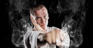 Siyah arka plandaki duman izlerinin üzerinde erkek dövüş sanatçısının kompozisyonu. spor ve yarışma konsepti dijital olarak oluşturulmuş görüntü.