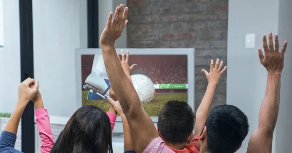 Composition of family of sports fans watching football match on tv, cheering with arms in the air. sport and competition concept digitally generated image.