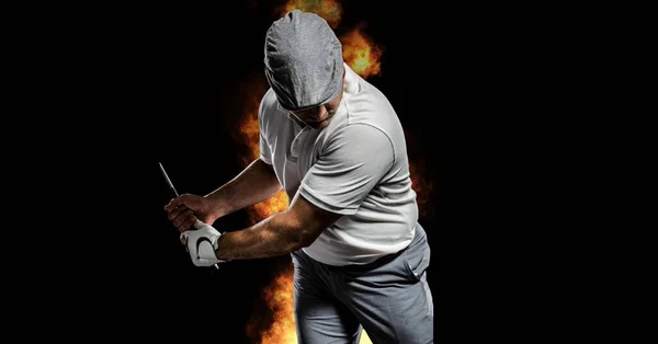 黒の背景に炎の上に男性のゴルフ選手の組成 スポーツと競争の概念をデジタルで生成し — ストック写真