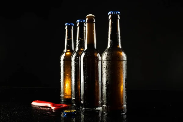 赤のボトルのオープナーと4本のビールボトルのイメージを1つのオープン 黒のコピースペースで アルコール リフレッシュメント ラガーデーのお祝いのコンセプト — ストック写真