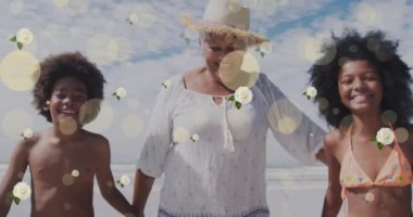 Sahildeki mutlu Afrikalı Amerikalı büyükanne ve torunlar üzerinde benekler ve çiçeklerin animasyonu. Çocukluk, eğlence, aile ve tatil konsepti dijital olarak oluşturulmuş video.