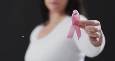 Siyah arka planda pembe kurdeleli beyaz bir kadın için umut mesajı. Göğüs kanseri farkındalığı konsepti dijital olarak üretilen video.
