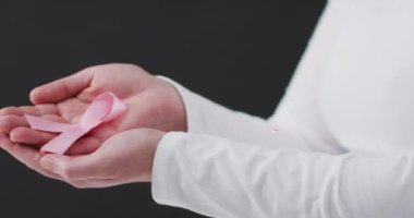 Siyah arka planda pembe kurdeleli beyaz bir kadın üzerinde inanç metninin animasyonu. Göğüs kanseri farkındalığı konsepti dijital olarak üretilen video.