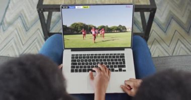 İki Afrikalı Amerikalının kanepede oturup dizüstü bilgisayardan futbol maçı izlediği bir video. Futbol ve tezahürat kavramı.