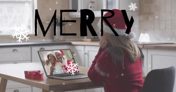 サンタの帽子の白人女性の上の陽気なクリスマスのテキストとクリスマスツリーのアニメーションは ビデオ通話を行います クリスマス コミュニケーション お祝いと伝統の概念デジタル生成ビデオ — ストック動画