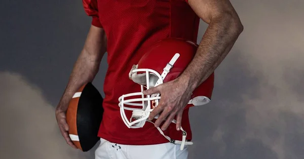 美国男性足球运动员带着球和头盔在蓝天与云的组合 体育和竞争概念数字生成的图像 — 图库照片