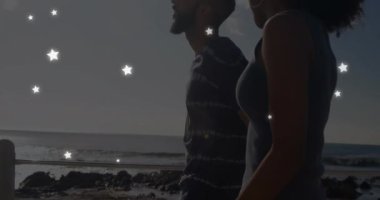 Sahildeki çeşitli çiftler üzerinde yıldızların animasyonu. Boş zaman ve dijital arayüz kavramı dijital olarak oluşturulmuş video.