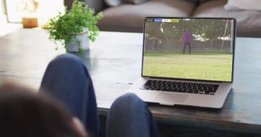 Kanepede oturup dizüstü bilgisayardan futbol maçı izleyen birinin videosu. Futbol ve tezahürat kavramı.
