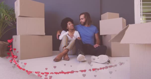 Animación Corazones Rojos Sobre Feliz Pareja Diversa Sentada Entre Cajas — Vídeo de stock