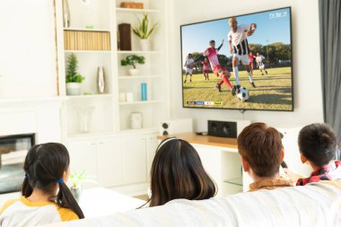 Çeşitli çocuklar televizyonda futbol maçı izliyorlar. Küresel spor ve kutlama konsepti, dijital kompozit görüntü.