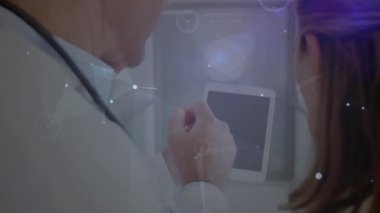 Laptop kullanan iki beyaz doktor üzerinden bağlantı ağının animasyonu. Küresel tıp ve veri işleme kavramı dijital video oluşturuldu.