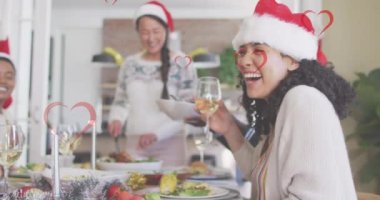 Noel 'de masada oturan farklı arkadaşlara karşı kalplerin animasyonu. Noel geleneği ve kutlama konsepti dijital olarak oluşturulmuş video.