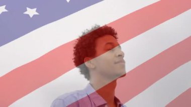 Mutlu Afro-Amerikan erkeği üzerinde dalgalı Amerikan bayrağının canlandırılması. Amerikan vatanseverliği kavramı dijital video üretimi.