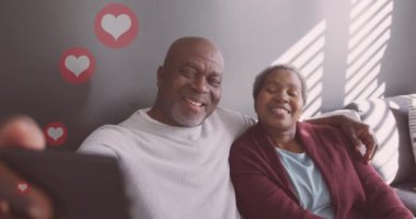 Yaşlı Afro-Amerikan çiftin Noel 'de selfie çekmesi üzerine kupa animasyonu. Noel geleneği ve kutlama konsepti dijital olarak oluşturulmuş video.