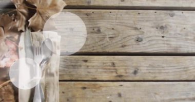 Çatal bıçak seti ve ahşap arka planda yaprakların üzerindeki ışık lekelerinin animasyonu. Sonbahar geleneği ve dijital olarak üretilen video konsepti.