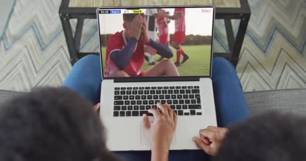 两个非洲裔美国人坐在沙发上 在笔记本电脑上观看足球比赛的视频 足球和欢呼的概念 — 图库视频影像