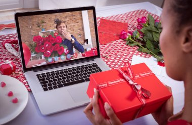 Çeşitli çiftler sevgililer günü için ellerinde hediyeler ve çiçeklerle dizüstü bilgisayardan video görüşmesi yapıyorlar. Karantina süresince çevrimiçi sevgililer günü.