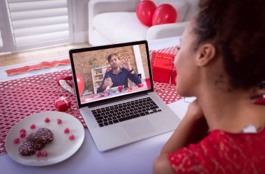 Sevgililer günü videosu çeken çeşitli çiftler dizüstü bilgisayardaki adamı yemek yerken arıyor. Karantina süresince çevrimiçi sevgililer günü.