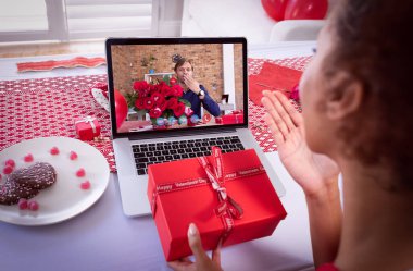 Çeşitli çiftler sevgililer günü videolarını dizüstü bilgisayarlarında, ellerinde hediyeler, çiçekler ve öpüşmeler eşliğinde çekiyorlar. Karantina süresince çevrimiçi sevgililer günü.