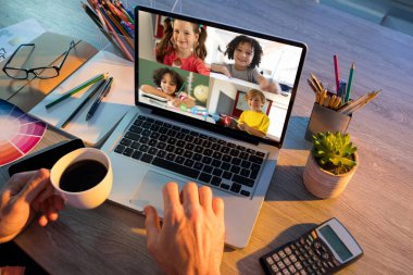 Erkek öğretmenle video görüşmesi sırasında dizüstü bilgisayardan öğrenilen öğrenciler. Çevrimiçi eğitim karantina süresince evde tek başına kalıyor..