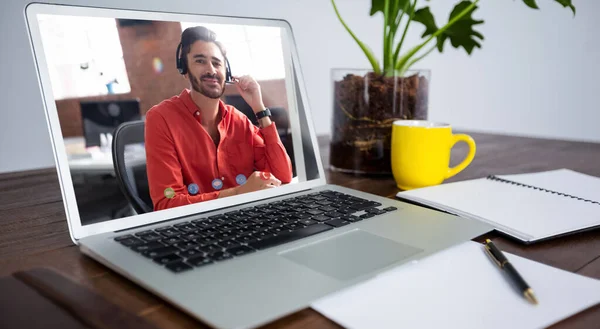 Laptop computer with a video call from businessman lying on desk. work at a modern office.