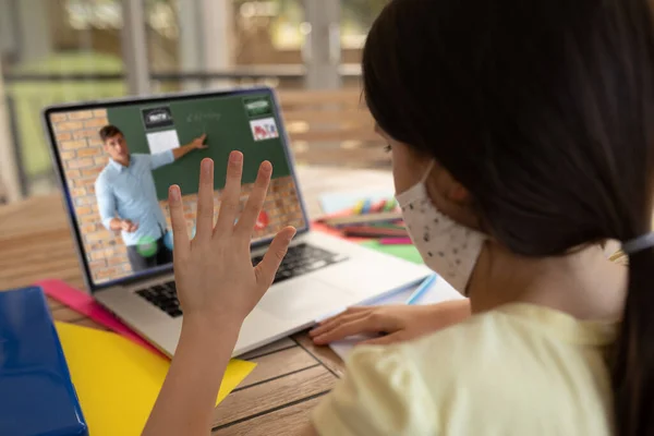 在学校 戴着面具的女学生在笔记本电脑上与男教师进行视频通话 Covid 19概念期间的在线远程教育 — 图库照片