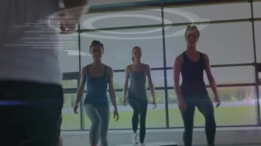 Veri işleme, tarama ve analiz animasyonları, arka planda bir spor salonunda spor yapan bir grup beyaz erkek ve kadınla birlikte.