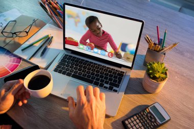 Erkek öğretmenle video görüşmesi sırasında dizüstü bilgisayardan öğrenen Afrikalı Amerikalı kız öğrenci. Çevrimiçi eğitim karantina süresince evde tek başına kalıyor..