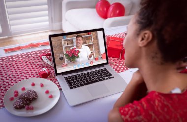 Sevgililer günü videosu çeken çeşitli çiftler dizüstü bilgisayardaki çiçek tutan adamı arıyor. Karantina süresince çevrimiçi sevgililer günü.