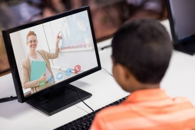 Erkek öğrenci okulda bilgisayar öğretmeniyle video görüşmesi yapıyor. uzak öğrenim çevrimiçi eğitim kavramı