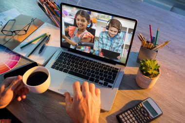 Erkek öğretmenle video görüşmesi sırasında dizüstü bilgisayardan öğrenilen öğrenciler. Çevrimiçi eğitim karantina süresince evde tek başına kalıyor..