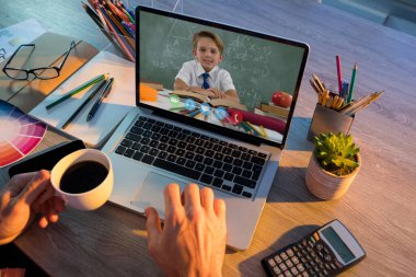 Erkek öğretmenle video görüşmesi sırasında beyaz öğrencilerin öğrenme yetenekleri dizüstü bilgisayarlarda sergilendi. Çevrimiçi eğitim karantina süresince evde tek başına kalıyor..