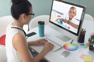 Beyaz kadın öğretmen okul çocuğuyla video görüşmesinde bilgisayar kullanıyor. Çevrimiçi eğitim karantina süresince evde tek başına kalıyor..